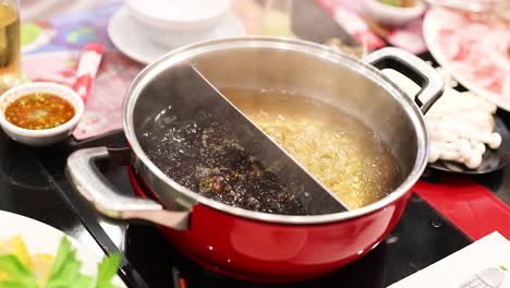 simmering hotpot with various ingredients and sauces