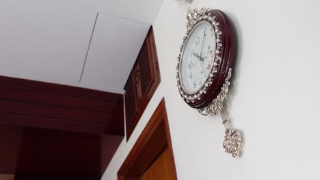 ornate wall clock with pendulum in an indoor setting