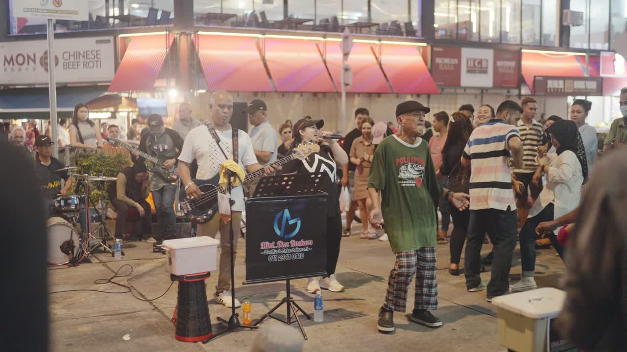 Slow motion shot of buskers performing at busy streets of Kuala Lumpur, Malaysia.
