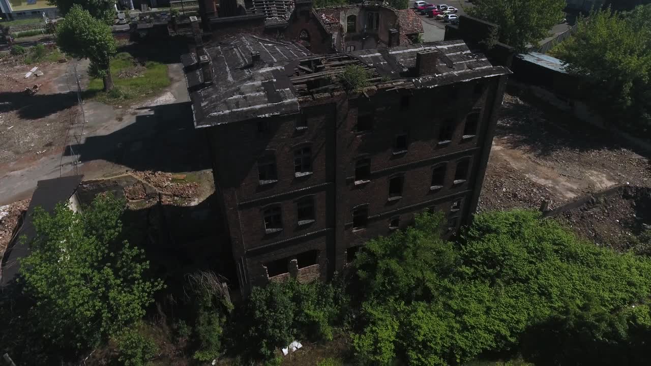 viejo, desmoronado edificio de ladrillo en europa central, sin ventanas, rodeado de árboles verdes en un soleado día de verano, disparo dinámico de dron 4k