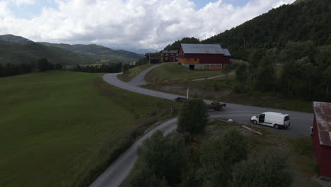 Toma-Aérea-De-La-Conducción-De-Automóviles-En-La-Carretera-En-Las-Tierras-De-Cultivo-De-Noruega