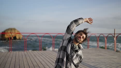 man stretching on a pier by the ocean