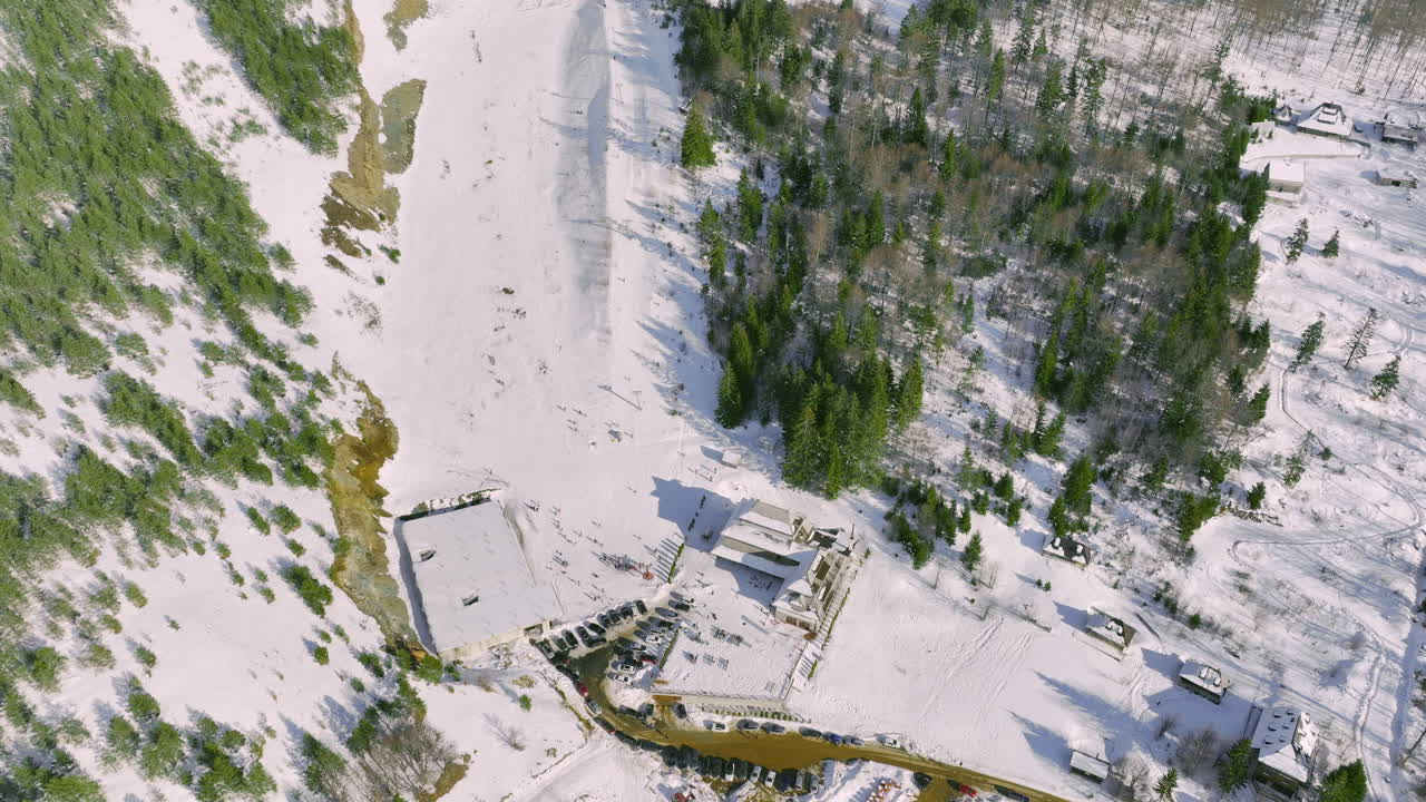 Aerial View of a Snowy Ski Resort in a Forested Mountain Landscape