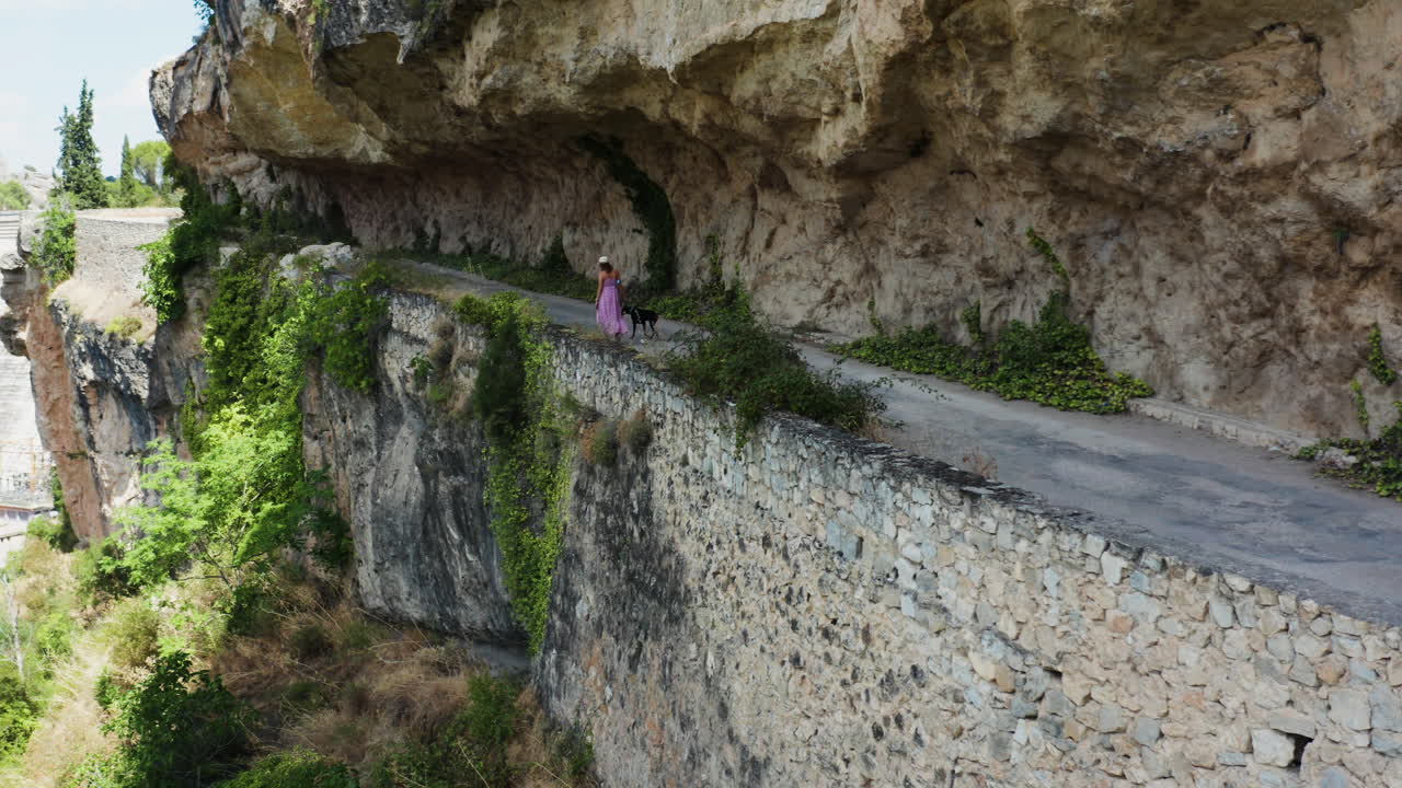 Panning shot fro Mirador al Puente Romano towards Presa Del Pantano. Woman Walking Dog.