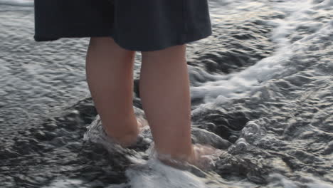 a slowmotion of waves washing childs feet