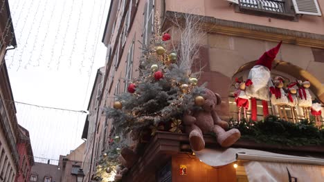 christmas trees and decorations on top of a european store front at festive christmas market in strasbourg, france europe