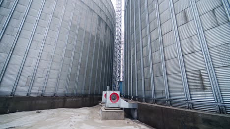 interior of the steel cisterns at modern elevator factory. working ventilators at the granary tank. going round the wide cistern of grain storage complex.