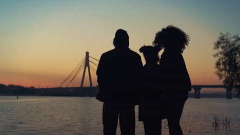 family silhouette watch sunset sky river. supportive parents kid enjoy evening