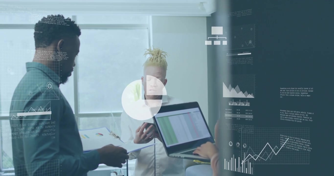Colleagues scanning report and laptop while tapping tablet showing tech graphs on glass partition