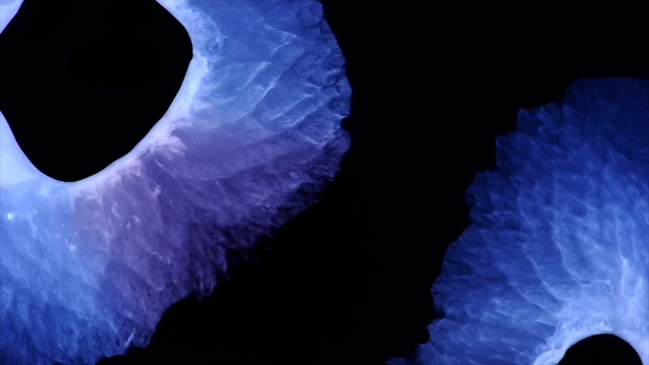 dos formas negras, cada una emitiendo púrpura, convergen