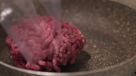 Person-Legte-Rohes-Hackfleisch-Aus-Einer-Plastikverpackung-In-Die-Pfanne