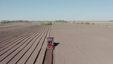 un tractor con cuchillas corta agujeros para preparar el campo antes de fertilizar y sembrar. vista aérea. maquinaria agrícola.