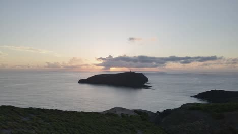 aerial drone flying from morenos viewpoint to ilheu de ferro island during sunset