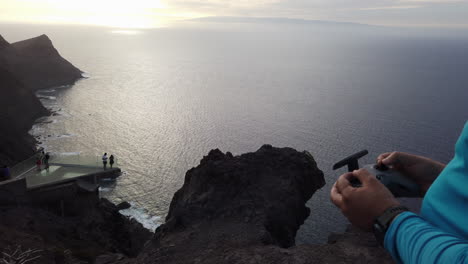 Primer-Plano-Del-Hombre-Usando-Drones-Fpv-De-Control-De-Radio-En-Un-Entorno-Montañoso-Durante-La-Puesta-De-Sol