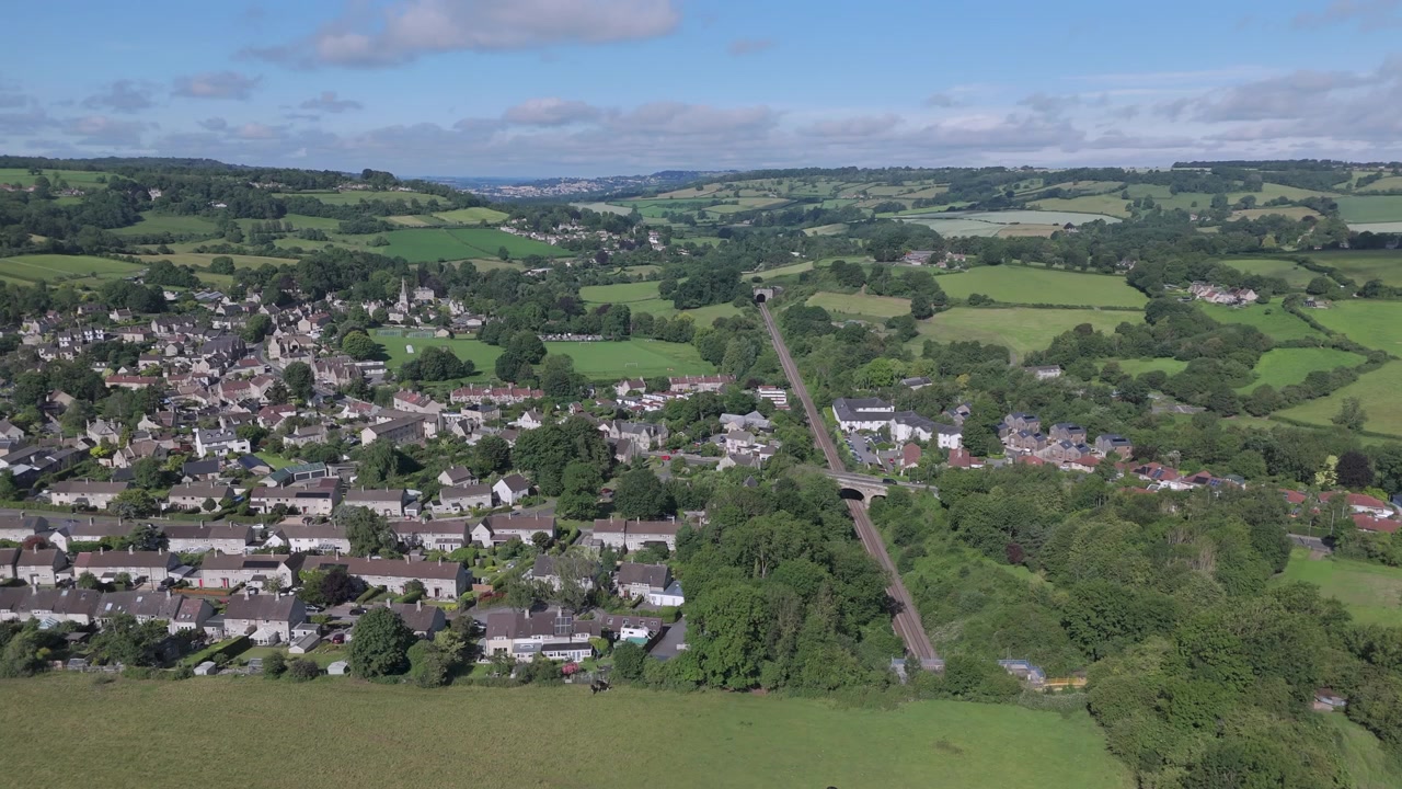 Partial, aerial orbit of Box village, Wiltshire and its railway tunnel on a Summer day