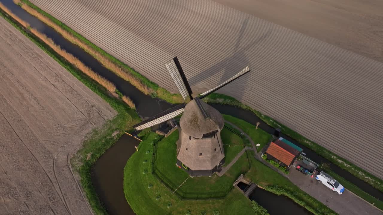 Pemandangan udara bilah kincir angin berputar di atas ladang datar, Belanda