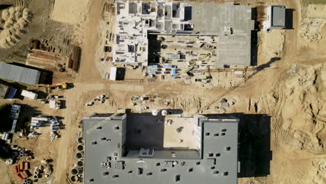 antena de arriba hacia abajo: sitio de construcción de arena construir bloques de viviendas altos durante el día soleado