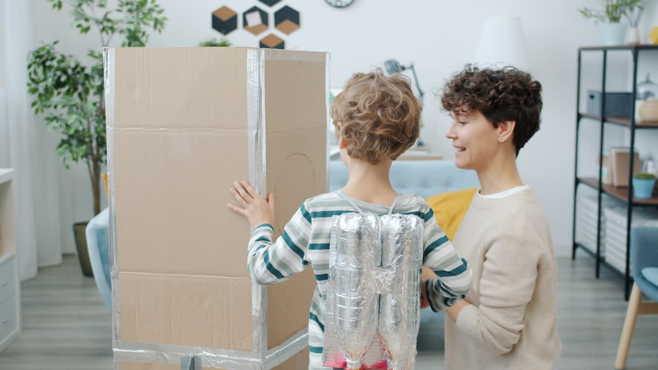 Kids crafting a cardboard rocket with mom