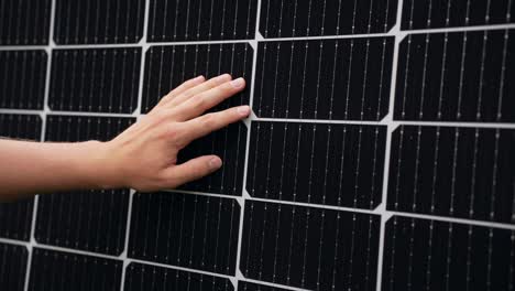 hand inspecting efficient solar panel, touching cells, closeup, static, day