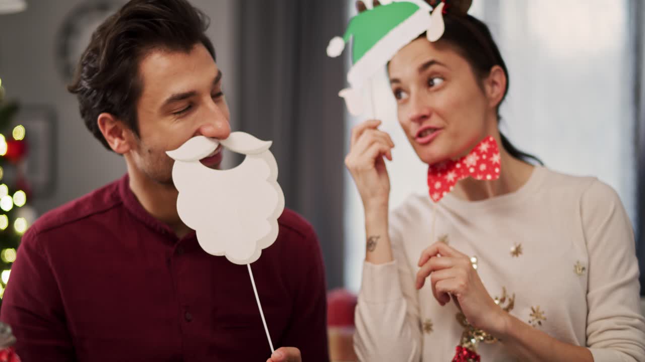 vista de mano de una pareja con máscaras de navidad divertidas