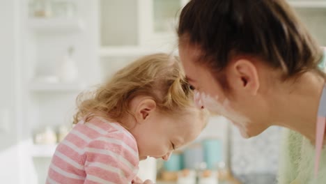 handheld view of mum and little girl playing with flour