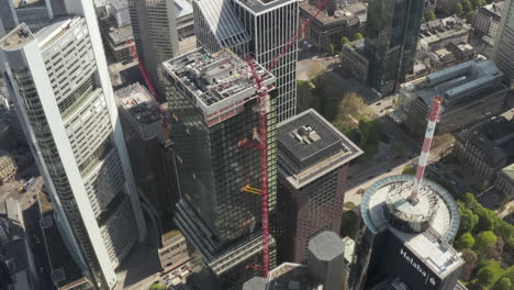 City-Skyline-with-Tower-under-construction-with-red-crane-in-sunny-daylight,-Aerial-Establishing-Shot-in-Frankfurt,-Germany