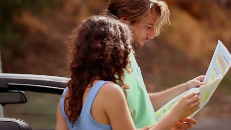 Pareja-Leyendo-Un-Mapa-Al-Costado-De-La-Carretera