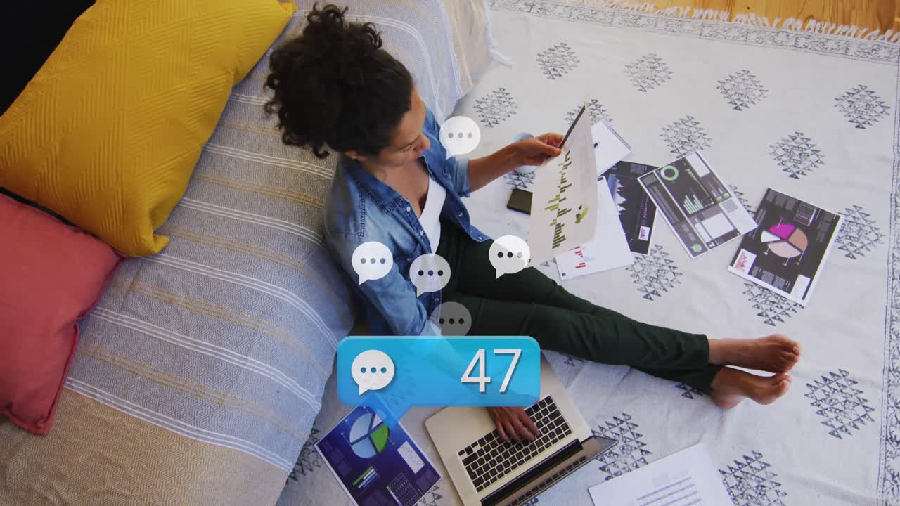 Animation of social media reactions over caucasian woman working on laptop