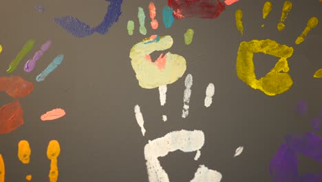 colorful handprints on grey wall