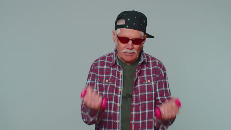 anciano anciano haciendo ejercicios de fitness con pesas solo, trabajando bombeando los músculos del brazo
