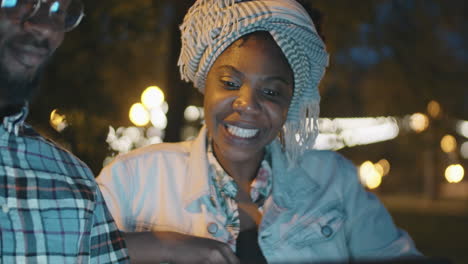 African-American-Man-and-Woman-Using-Laptop-and-Talking-Outdoors-in-Evening