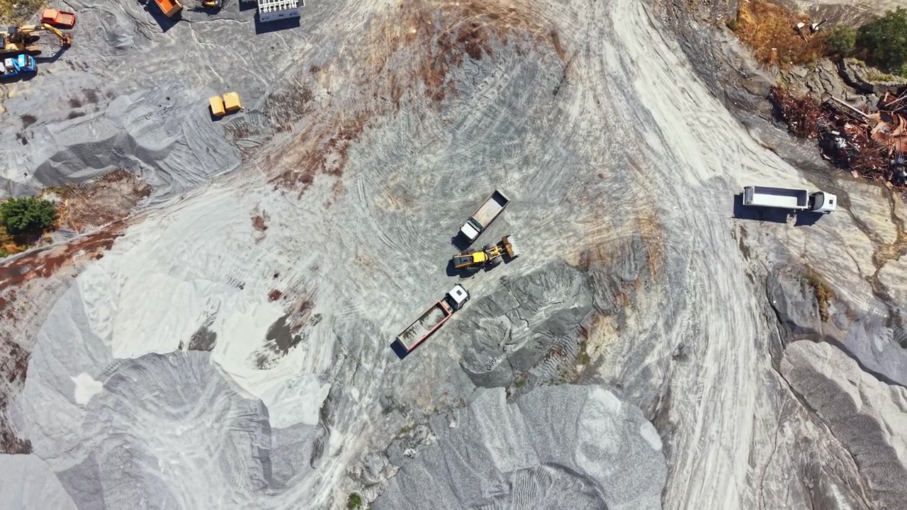 Granite quarry located in a remote area with machinery and vehicles working on the site