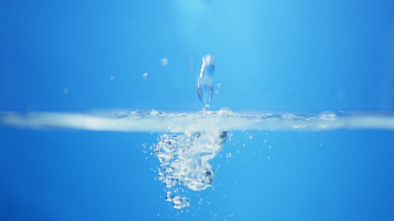 Incredible close-up shot of water in slow motion, capturing the essence of purity and the beauty of blue waves on the surface.