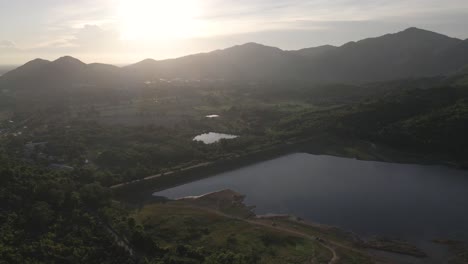 Imágenes-Aéreas-De-4k-Volando-Alto-Con-La-Luz-Del-Sol-Sobre-Las-Montañas-En-El-Fondo-Cerca-Del-Embalse-De-Khlong-Bod-En-Nakhon-Nayok,-Tailandia