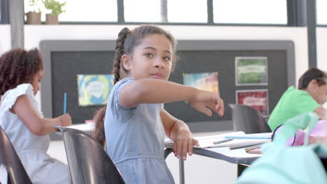 biracial girl smiles in a classroom setting at school