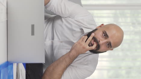 vertical video of home office worker man thinking worriedly.