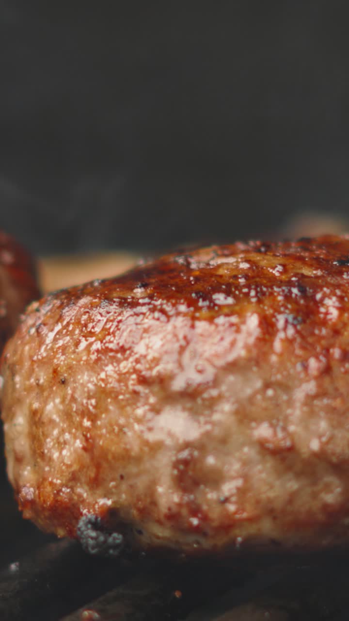 Vertical Video with Beef Burger with Juices Bubbling from Hot BBQ Grill with Smoke Swirling. Close Up Outdoor Cooking Meat