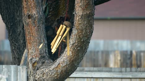 Fierce 70-80 mile per hour winds blow and knock to and fro a wind chime cause it to flail wildly in the strong forced breeze