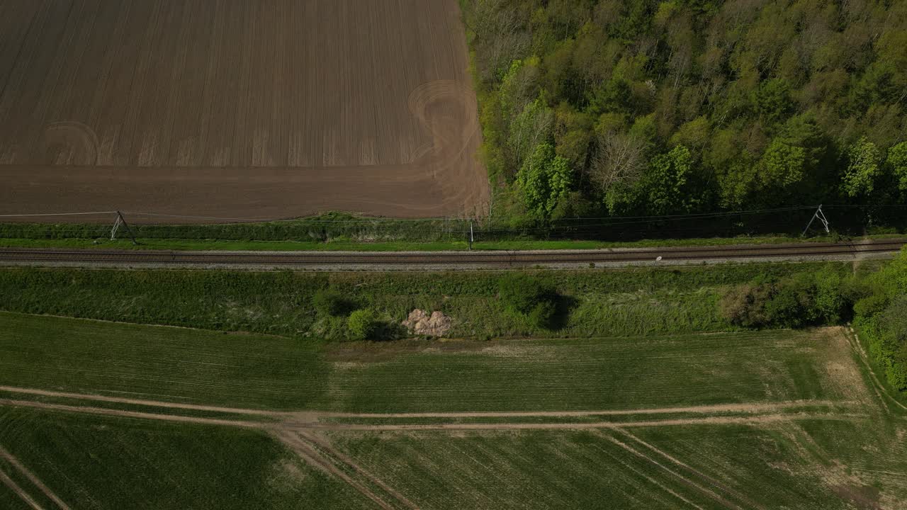 트랙의 양쪽에 이 있는 시골을 지나가는 열차의 드론 영상
