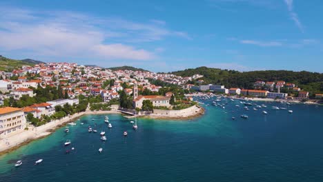 Panorama-of-a-coastal-town-with-many-houses-with-red-roofs,-surrounded-by-the-sea-and-mountains