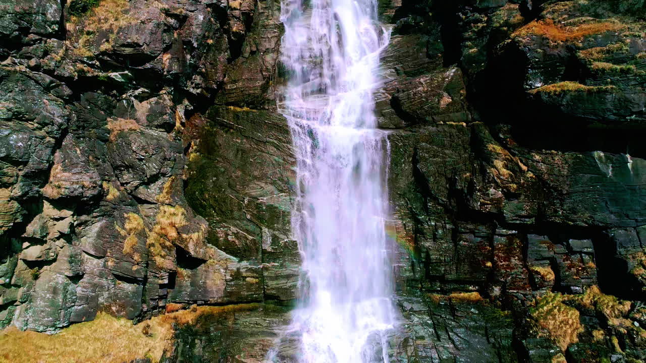 imágenes de drones descendiendo de una hermosa cascada que fluye por las rocas