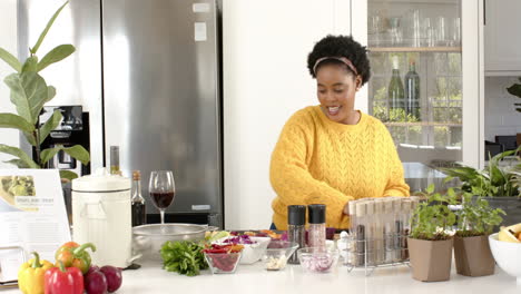play back cookery show of an african american woman shaking a spice container in the kitchen