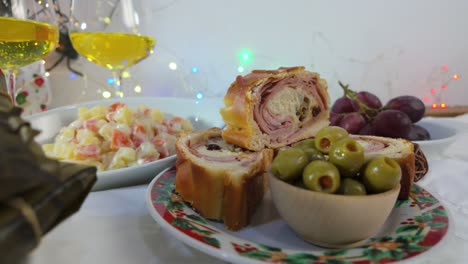 traditional venezuelan christmas dish with ham bread, olives, grapes and festive lights