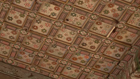 painted traditional korean ceiling with floral patterns in pastel tones. framed by wooden lattice beams in square grid layout.. low angle shot