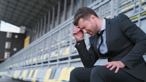 Stressed businessman in stadium