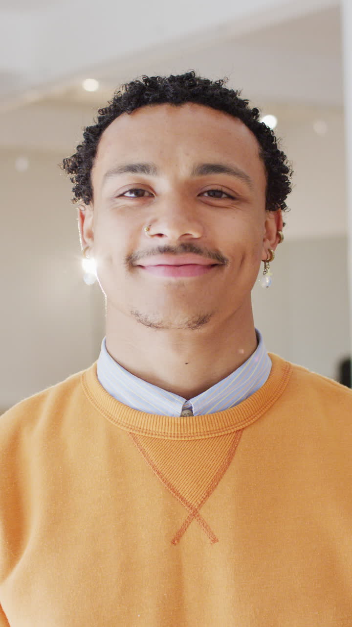 Vertical video of portrait of happy biracial man in dance studio