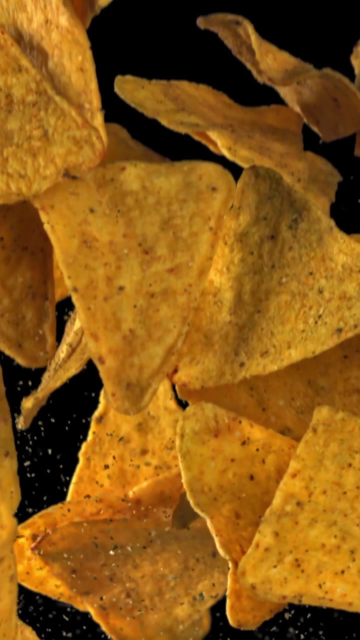 Tortilla chips che cadono e fluttuano con condimento al rallentatore