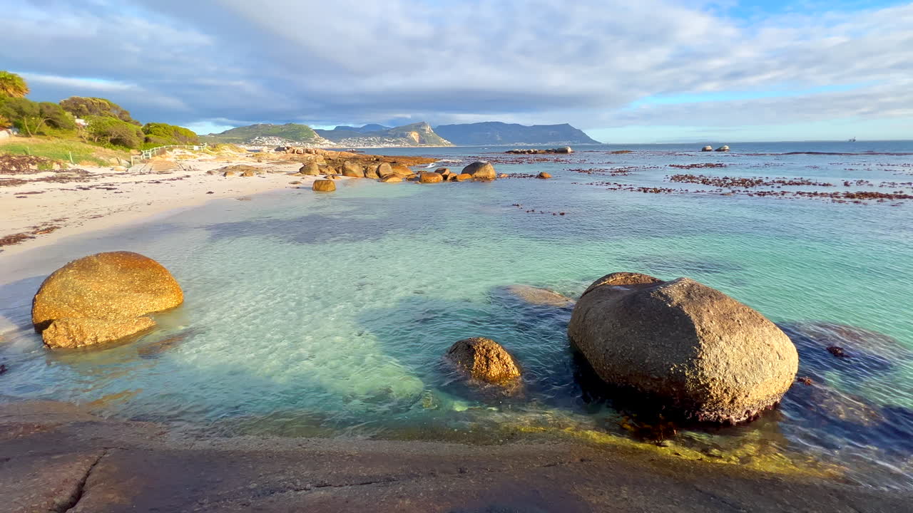 Boulder's Beach South Africa Simon's Town Penguin Colony public swimming area Water's Edge South Africa Netflick Penguins Town early morning sunrise scenic coastline Cape Town slow motion pan right