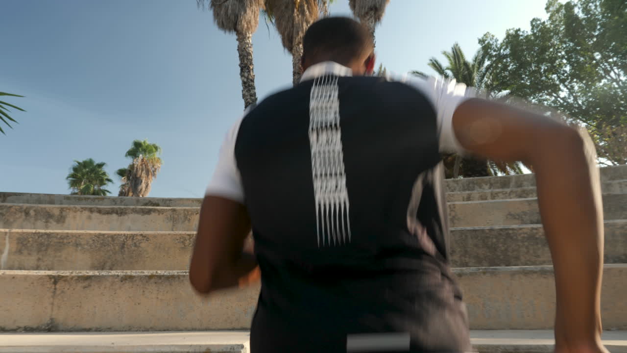 joven corredor negro subiendo escaleras y entrenando al aire libre