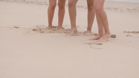 medium shot of legs of caucasian girls moving during a photo shoot in the sand of a beach at daylight